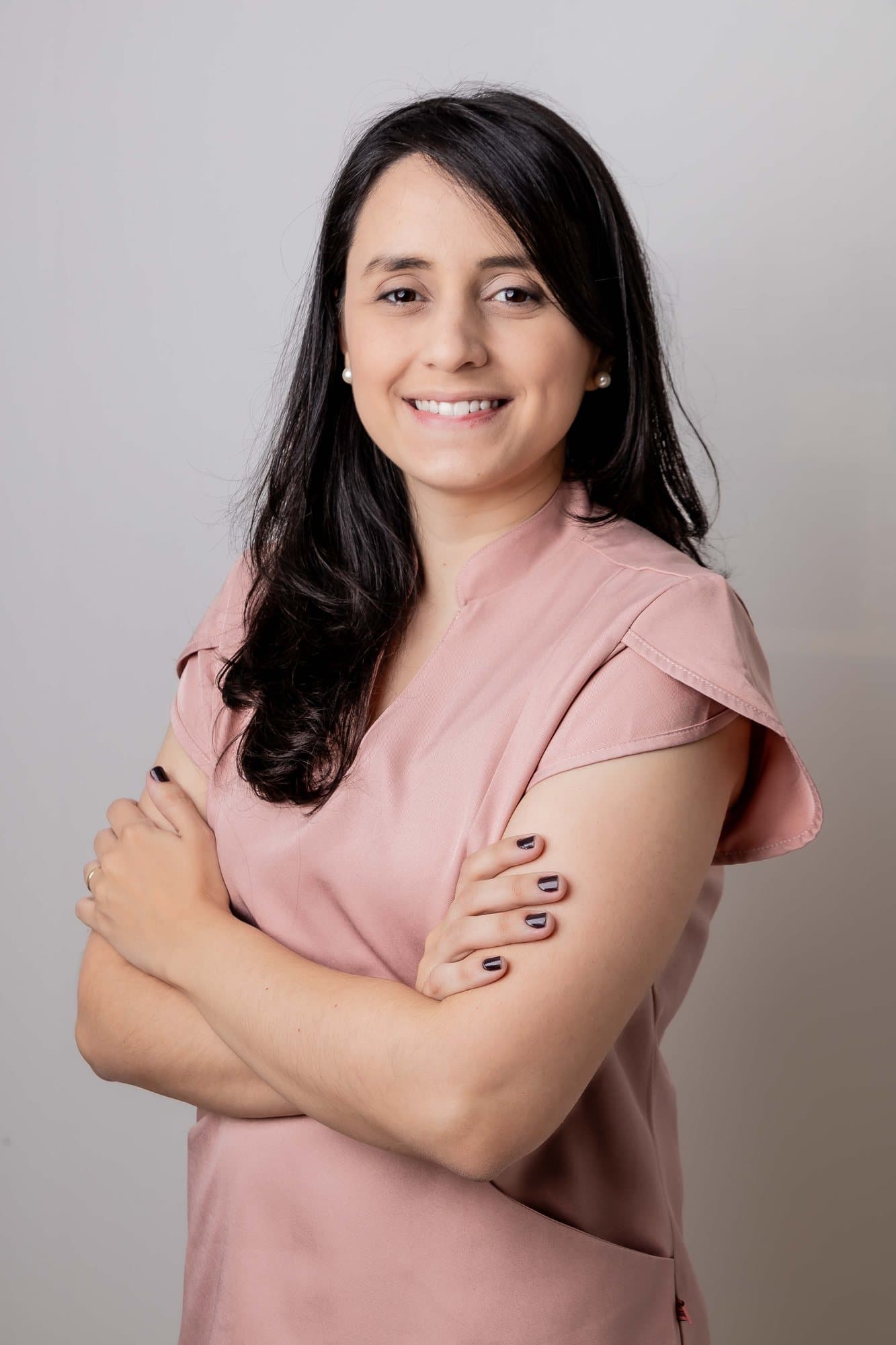 Dra. Paula Azevedo de braços cruzados no consultório